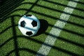 Soccer ball black and white on artificial ground ground with shadows stripes, over the line Royalty Free Stock Photo