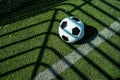 Soccer ball black and white on artificial ground ground with shadows stripes, over the line Royalty Free Stock Photo