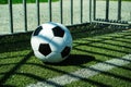 Soccer ball black and white on artificial ground ground with shadows stripes, over the line Royalty Free Stock Photo