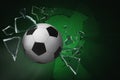 Soccer ball breaking up glass against green background Royalty Free Stock Photo