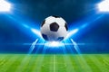 Soccer ball, bright spotlights, illuminates green soccer stadium Royalty Free Stock Photo