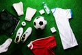 Soccer ball,cleats and various football stuff against artificial Royalty Free Stock Photo