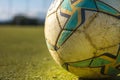 Soccer ball in close up with the goal in the background out of focus in a 5-a-side football field