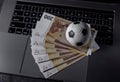 Soccer ball and euro banknotes on a keyboard. Sport, gambling, money win concept Royalty Free Stock Photo