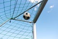 Soccer ball flying into football goal net over sky Royalty Free Stock Photo