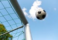 Soccer ball flying into football goal net over sky Royalty Free Stock Photo