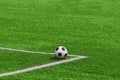 A soccer ball framed by white corner markings on a green football field. Royalty Free Stock Photo