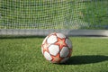 Soccer ball in the goal with a net on  football field of a sports stadium Royalty Free Stock Photo