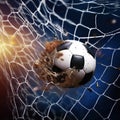 Soccer ball in goal net. Soccer ball tearing and breaking football net. Royalty Free Stock Photo