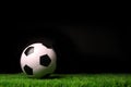 Soccer ball on grass against black Royalty Free Stock Photo