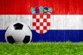 Soccer ball on grass with Croatia flag background