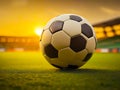 Soccer ball on the grass of a soccer field in golden sunset light. generative AI Royalty Free Stock Photo