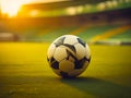 Soccer ball on the grass of a soccer field in golden sunset light. generative AI Royalty Free Stock Photo