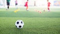 Soccer ball on green artificial turf with blurry kid soccer team training Royalty Free Stock Photo