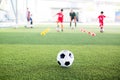 Soccer ball on green artificial turf with blurry kid soccer team training Royalty Free Stock Photo