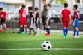 Soccer ball on green artificial turf with blurry soccer team training Royalty Free Stock Photo