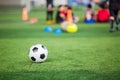 Soccer ball on green artificial turf with blurry soccer team training Royalty Free Stock Photo