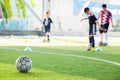 Soccer ball on green artificial turf with blurry soccer team training Royalty Free Stock Photo