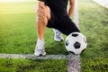 Soccer ball on green artificial turf with footballer is sitting and catch the knee Royalty Free Stock Photo