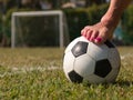 Soccer ball in a green field near a five-a-side goal, outdoor