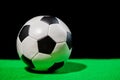 soccer ball on green grass over black background Royalty Free Stock Photo
