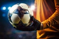 The soccer ball is held securely in the close up of the goalkeepers hands