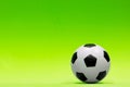 Soccer ball isolated against a plain green background.