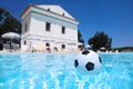 Soccer ball lies in water in pool