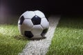 Soccer ball low angle view on white stripe of grass field with dramatic lighting and dark background Royalty Free Stock Photo