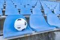 Soccer ball in a medical mask on the background of empty stands . Royalty Free Stock Photo