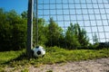 Soccer ball is next to the pole of a goal with chains, football for kids