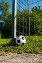 Soccer ball is next to the pole of a goal with chains, football for kids