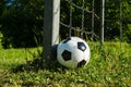 Soccer ball is next to the pole of a goal with chains, football for kids