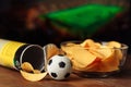 Soccer ball with potato chips in a bowl and screen with football game