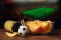 Soccer ball with potato chips in a bowl and screen with football game background