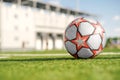 Soccer ball with red stars on the green artificial grass of the football field in the stadium Royalty Free Stock Photo