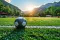 A soccer ball sits on a lush green field at sunset Royalty Free Stock Photo