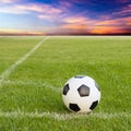 Soccer ball on soccer field against sunset sky Royalty Free Stock Photo