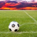 Soccer ball on soccer field against sunset sky Royalty Free Stock Photo