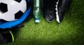 Soccer ball, in a sports bag, a bottle of water and black boots, against the background of grass Royalty Free Stock Photo