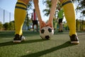 Soccer ball and sportsman legs over grass football field Royalty Free Stock Photo