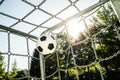 Soccer ball in top corner of the goal in summer