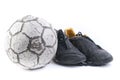 Soccer ball with two old black shoes Royalty Free Stock Photo