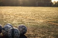 Soccer balls on the field, for playing ball. Against the background of the gate. Warm tinting. Low morning light Royalty Free Stock Photo