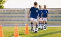 Soccer camp for kids. Boys practice dribbling in a field. Players develop good soccer dribbling skills. Children training with