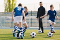 Soccer camp for kids. Boys practice football dribbling in a field. Players develop soccer dribbling skills. Children training Royalty Free Stock Photo