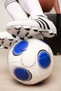 Soccer cleats stepping on a ball