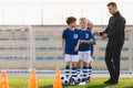 Soccer Coach Motivating Kids on Training. Young Coach With Kids in Soccer Team on Training Unit. Coach on Training with School Boy