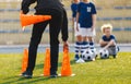 Soccer Coach Placing Training Cones for Kids Sports Team. Children on Soccer Football Class Royalty Free Stock Photo