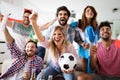 Soccer fans emotionally watching game in the living room. Royalty Free Stock Photo